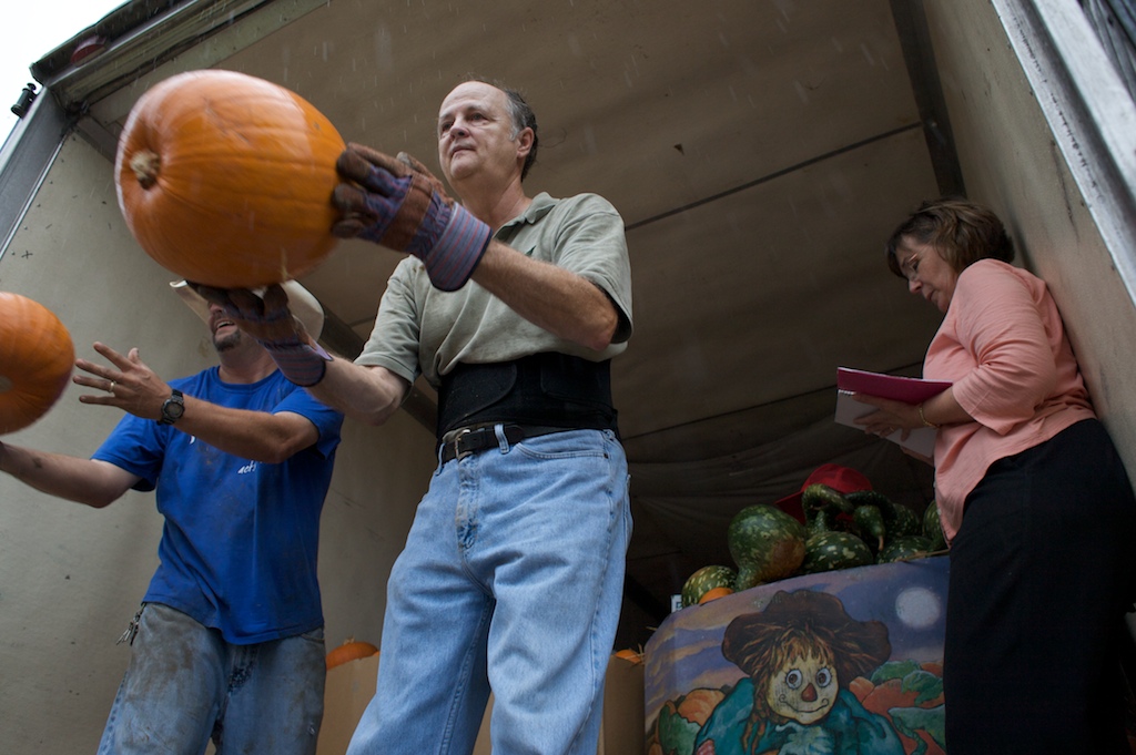 Volunteers with Dauphin Way United Methodist Church unload hundreds of pumpkins during a rain shower Thursday, Oct. 22, 2009, at the church's pumpkin patch in Midtown Mobile, Ala.