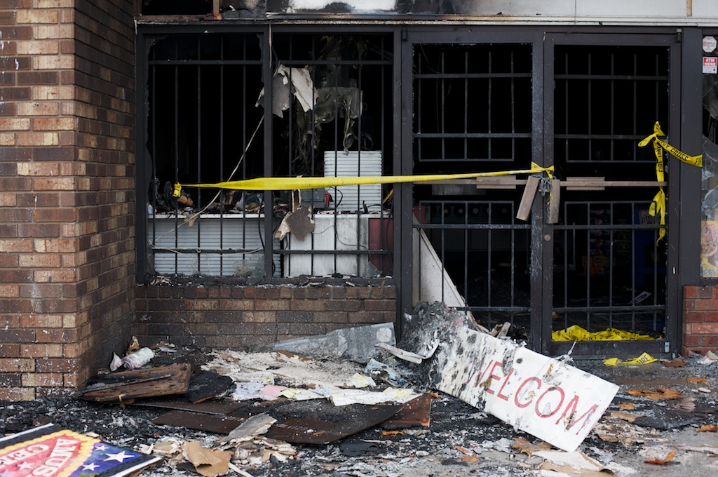 A welcome sign sits in front of a convenience store damaged by a recent fire Sunday, Jan. 24, 2010.