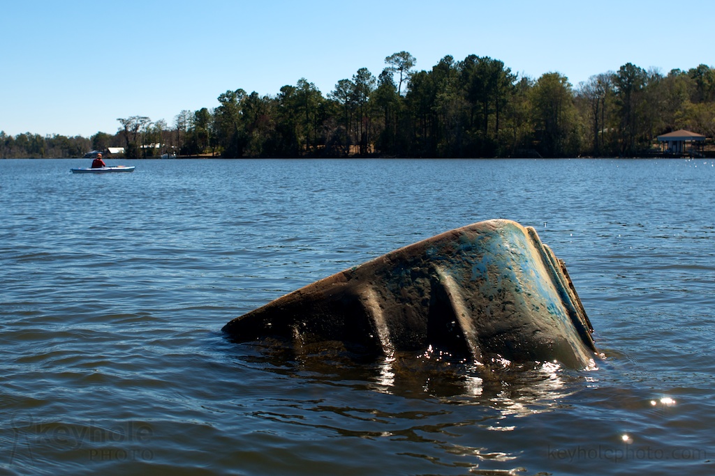 The back of an abandoned boat is all that sticks above the surface of Dog River in Mobile, Ala., Sunday, Feb. 28, 2010.