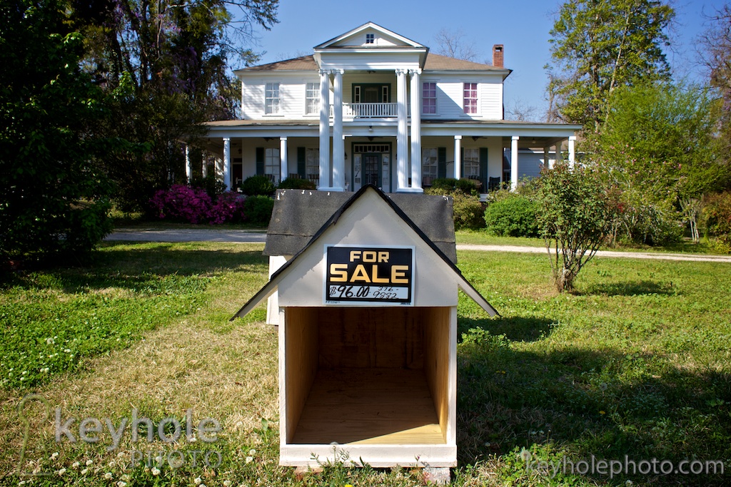 A doghouse for sale sits in front of a beautiful home in Georgiana, Ala., Sunday afternoon, April 4, 2010.