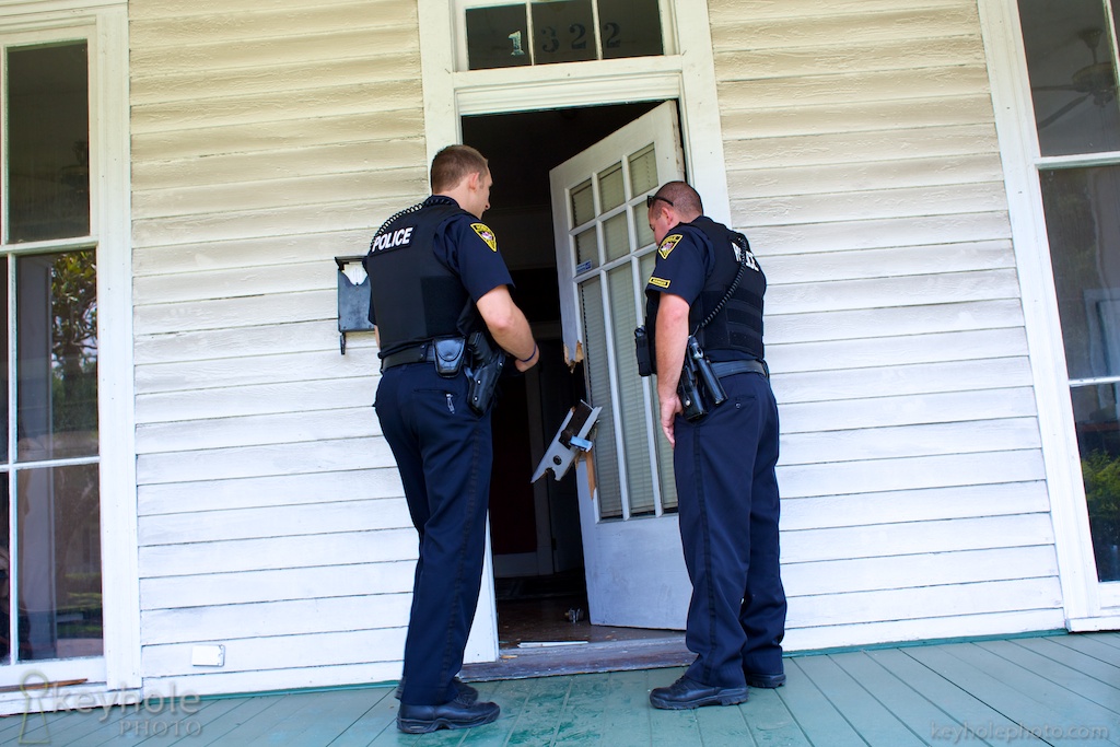 Police officers examine a broken door after a house burlgary in Midtown Mobile, Ala., Tuesday, May 25, 2010.