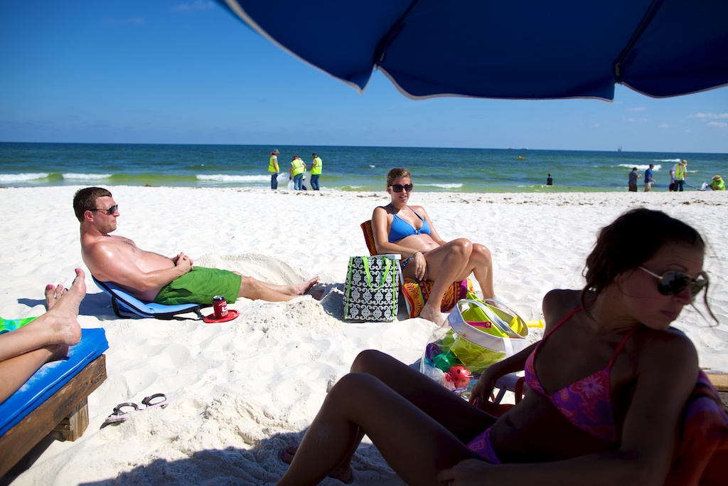 People hang out at the beach in Florida near the Alabama state line as crews clean up oil from the Deepwater Horizon oil spill Thursday, June 10, 2010.