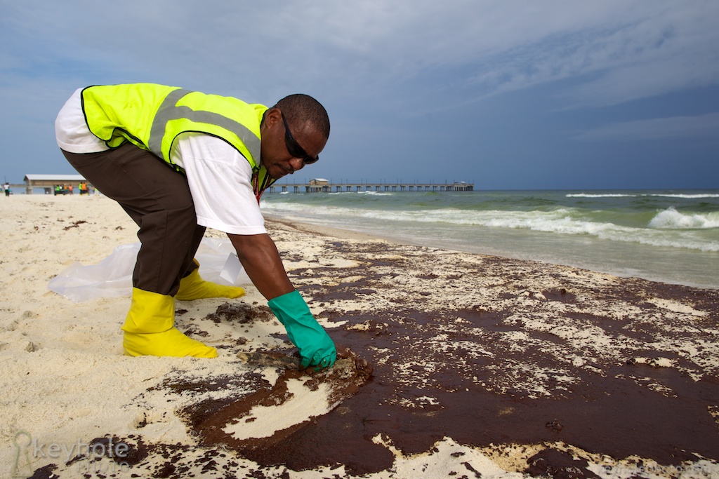 Steve Gardner cleans oil from the white sand beaches of Gulf State Park in Gulf Shores, Ala., Friday, June 4, 2010. Goo from the Deepwater Horizon Oil Spill began washing ashore earlier in the day, threatening the state's tourism.
