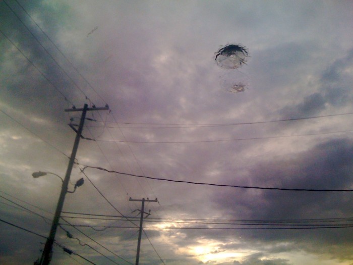 A dramatic sky is reflected in a plate glass window that includes a bullet hole at a shop on Airport Boulevard in Mobile, Ala., Tuesday, Aug. 18, 2009.