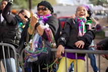 Revelers catch beads during a parade.