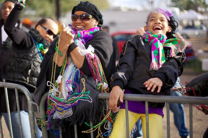 Revelers catch beads during a parade.