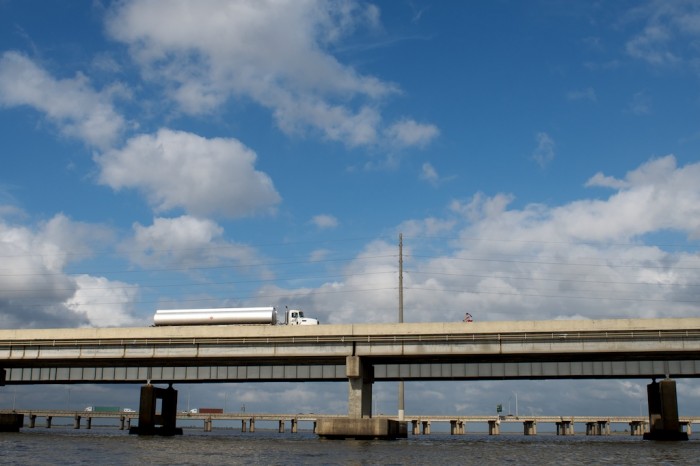 A bicyclist crosses a bridge as a tanker heads eastbound Thursday, Oct. 29, 2009.