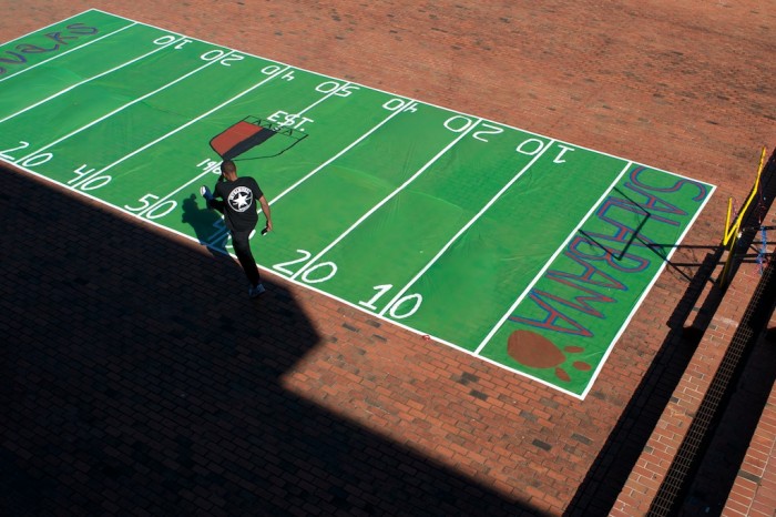 A man walks by a football field laid down on the bricks near the student center at the University of South Alabama in Mobile, Ala., Monday, Nov. 2, 2009.