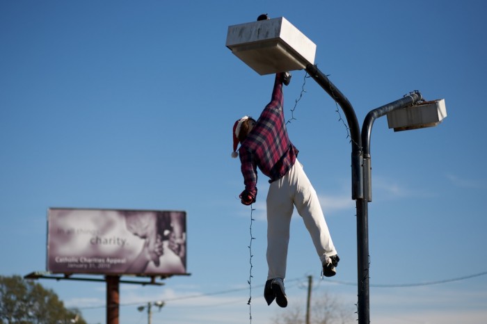 A stuffed body, simulating a failed attempt to hang Christmas lights, hangs from a light post along Old Shell Road in Mobile, Ala., Friday, Christmas day, Dec. 25, 2009.