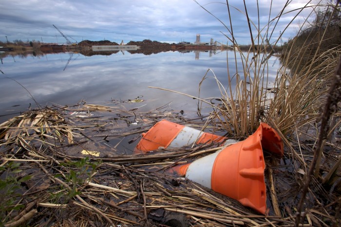 An abandoned construction barrel sits in debris on the shore along a waterway north of downtown Mobile, Ala., Sunday afternoon, Feb. 21, 2010.