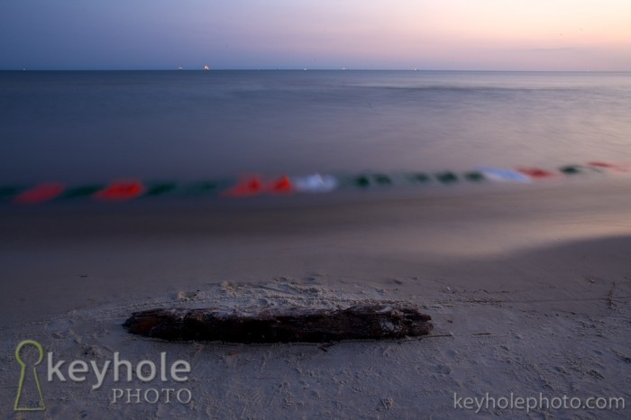Waves and water blur together, along with colorful material placed along the shoreline of Dauphin Island, Ala., Saturday, May 8, 2010.v