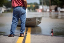 A man stands at water's edge as the Blanchard River flows over Ohio Highway 65 in Ottawa, Ohio, Thursday, Aug. 23, 2007.