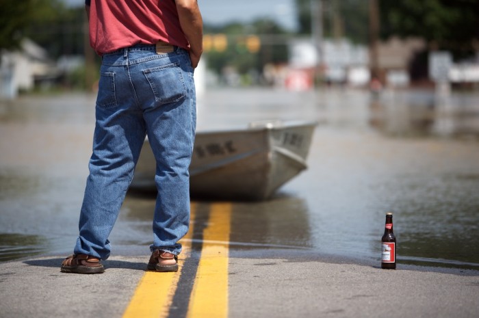 A man stands at water's edge as the Blanchard River flows over Ohio Highway 65 in Ottawa, Ohio, Thursday, Aug. 23, 2007.