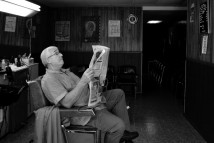 Don Mayer reads the paper during a lull in business at Mick's Barber Shop in Pomeroy, Ohio, Tuesday, Oct. 3, 2006.