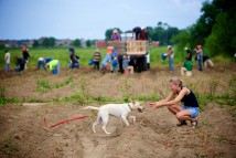 Katie Murphy lets her dog, Azalea, play in the harvested rows of sweet potatoes in the field in front of her home as a crew of workers harvests sweet potatoes at Penry Farms in Belforest, Ala., Tuesday, July 28, 2009.