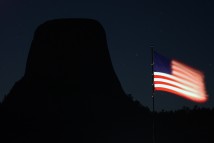 The American flag waves in the morning breeze by a silhouette of Devils Tower in Wyoming before sunrise Oct. 19, 2002.