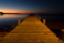 A dock is illuminated by park lights after the sun sets over Mobile Bay in Fairhope, Ala., Saturday, Nov. 28, 2014.